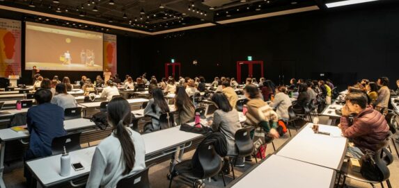 A diverse group attending a conference in a modern hall in Gwangju, South Korea.