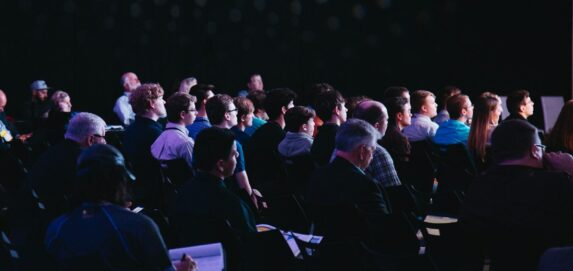 crowd of people sitting on chairs inside room
